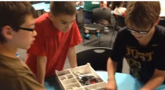three students using electrical equipment